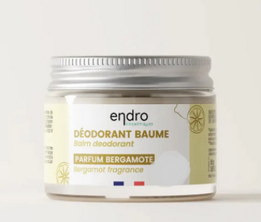 Natürliches Kokos-Deo im Glastiegel mit Spatel auf hellem Hintergrund